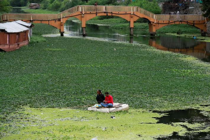 Hai người đàn ông Kashmir ngồi câu cá ở Srinagar hôm 17/8.