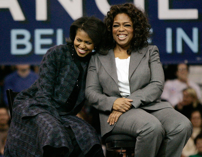 Bà Michelle Obama, phu nhân của cựu Tổng thống Mỹ Obama, cười tươi khi ngồi cạnh người dẫn chương trình truyền hình Oprah Winfrey tại Manchester ngày 9/12/2007.