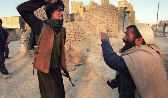 Một thành viên Taliban đánh đập người đàn ông bị bắt khi mang nửa kg thuốc phiện.