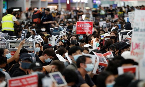 Phóng viên CNN đưa tin, hàng trăm người biểu tình đứng chặn tại các cửa ra vào khu vực kiểm soát an ninh và ngăn hành khách ra cửa đi lên máy bay.