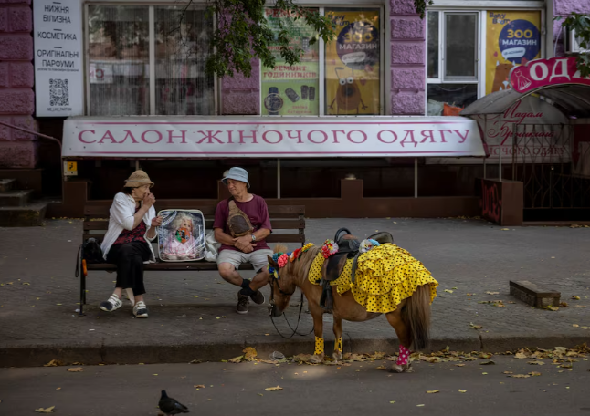 Một phụ nữ ngồi trò chuyện với một người đàn ông trên phố đi bộ ở Mykolaiv, Ukraine, ngày 04/07/2024.