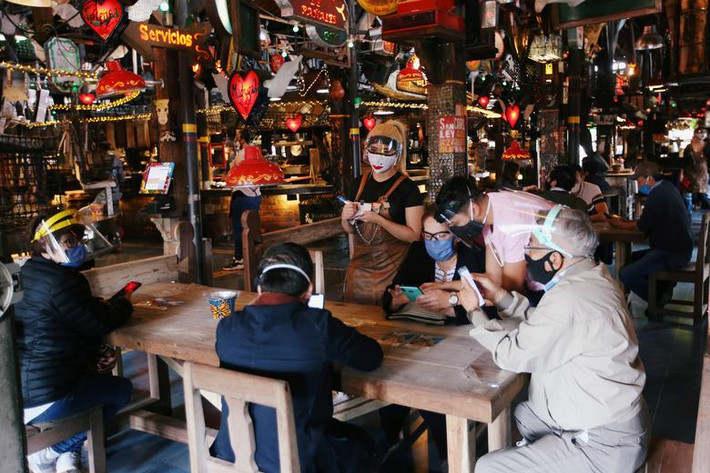 Nhân viên và thực khách tại nhà hàng Andres Carne de Res đeo khẩu trang và đội mũ chống giọt bắn tại Chia, Colombia, ngày 30/8.