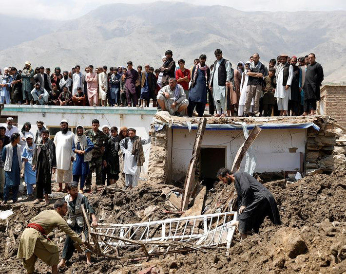 Mọi người tìm nạn nhân còn sống sót sau trận lũ ở Charikar, tỉnh Parwwan, Afghanistan, ngày 27/8.