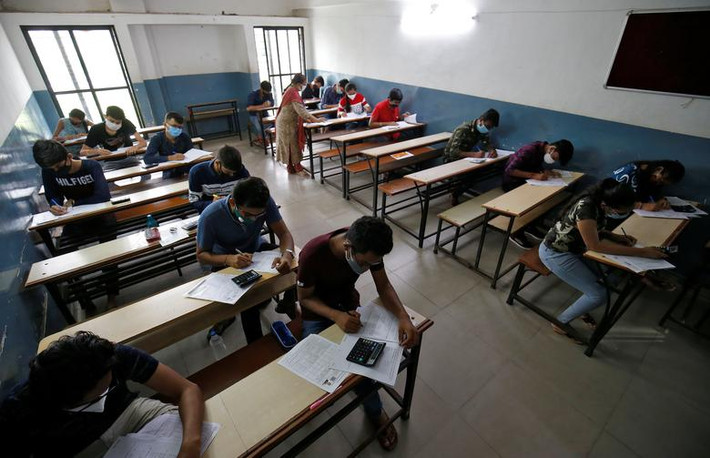 Học sinh đeo khẩu trang và ngồi cách nhau trong phòng học ở Ahmedabad ngày 24/8.