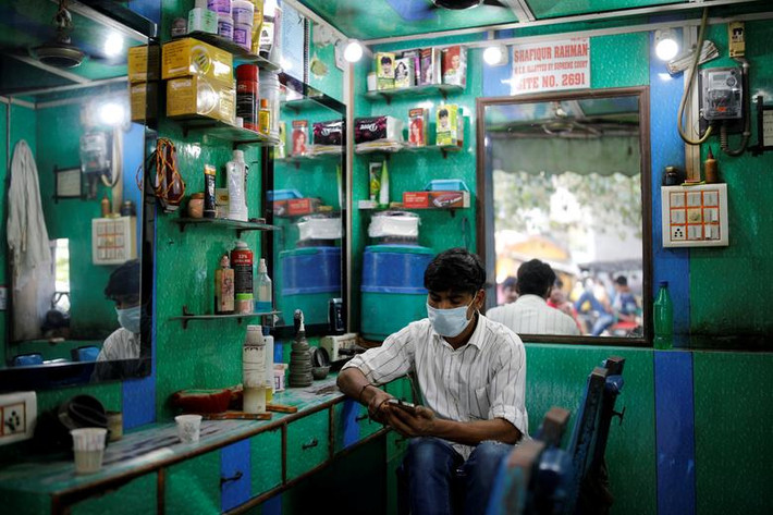 Bên trong một tiệm cắt tóc vắng khách ở Delhi hôm 24/8.