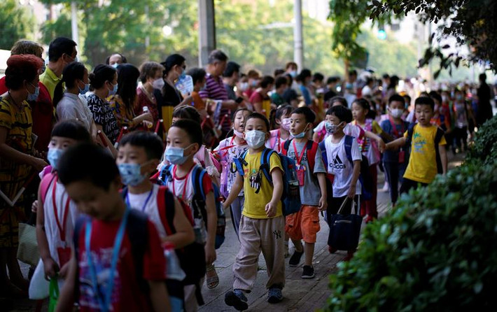 Các em học sinh đeo khẩu trang bên ngoài một trường tiểu học ở Vũ Hán hôm 2/9.