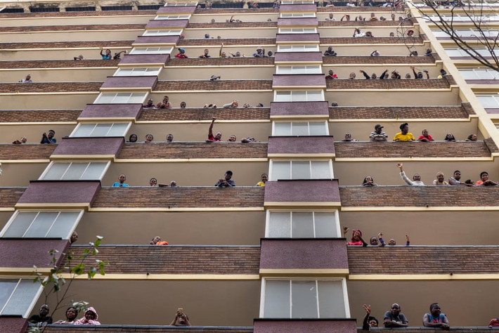 Cư dân trong khu Hillbrow, Johannesburg, vẫy chào từ ban công trong thời gian phong tỏa vì COVID-19. Ảnh: AP.