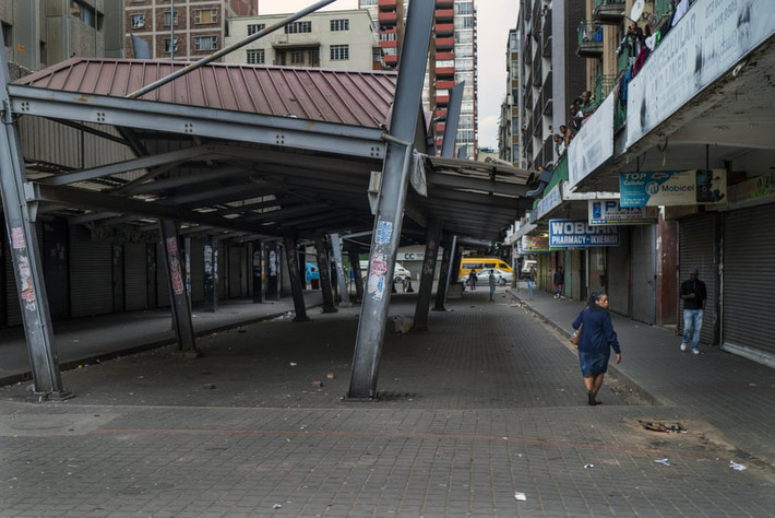 Người dân đi bộ trên những con phố vắng vẻ ở Johannesburg ngày 29/3. Ảnh: AP.