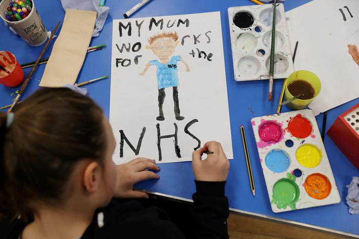 Một em nhỏ tại trường Tiểu học Westlands vẽ tranh cổ vũ nhân viên y tế NHS tại Newcastle-under-Lyme ngày 2/4.