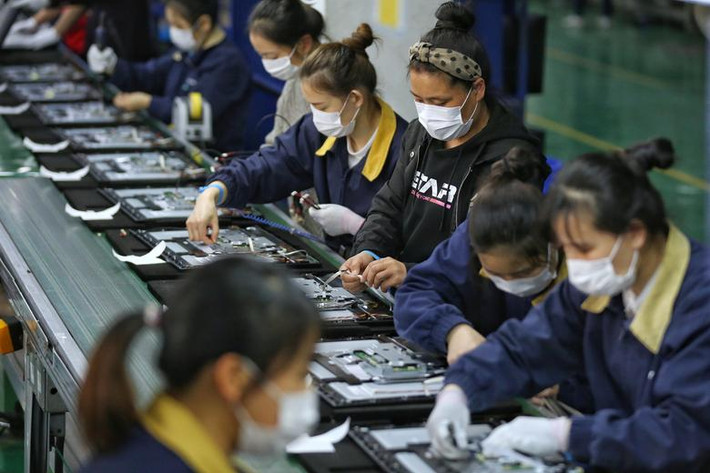 Các công nhân đeo khẩu trang làm việc trong một nhà máy ở thành phố Vũ Hán.