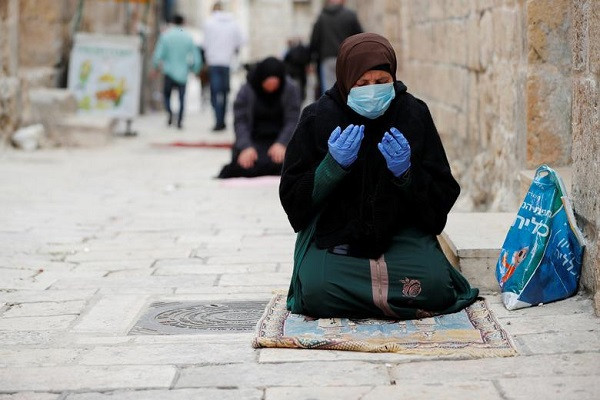 Người phụ nữ đeo khẩu trang và găng tay khi cầu nguyện ở Thành phố cổ Jerusalem trong ngày đầu tiên của tháng lễ Ramadan năm 2020.