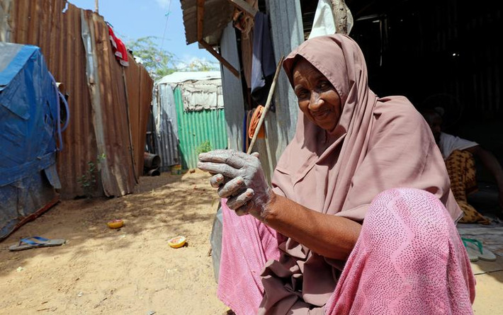 Người phụ nữ Somalia sử dụng tro và đất để rửa tay tại khu trại Shabelow cho người sơ tán trong nước ở Moghadishu, Somalia, ngày 1/4.