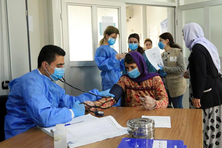 Bác sĩ kiểm tra huyết áp của một phụ nữ Yazidi tại trung tâm y tế của khu trại Sharya ở Duhok, Iraq, ngày 7/3.