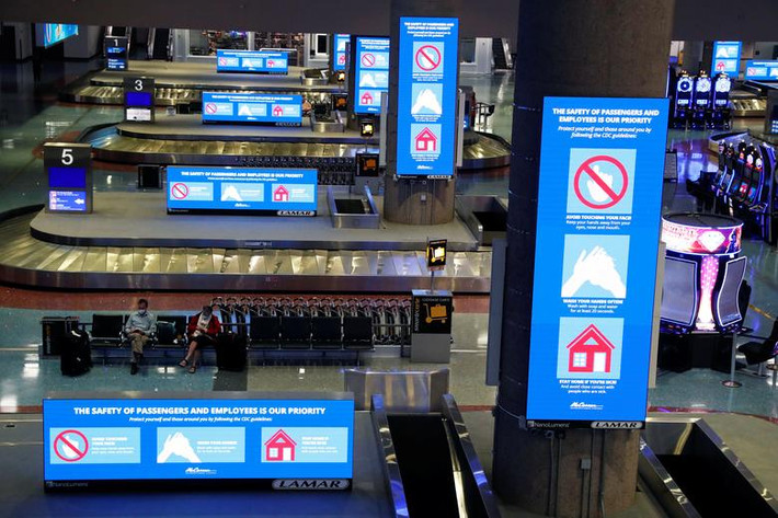 Một vài hành khách đeo khẩu trang ngồi trong sân bay quốc tế McCarran ở Las Vegas hôm 9/4.