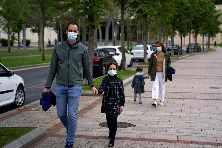 Các bậc phụ huynh đeo khẩu trang dẫn con cái đi dạo ở Bilbao.