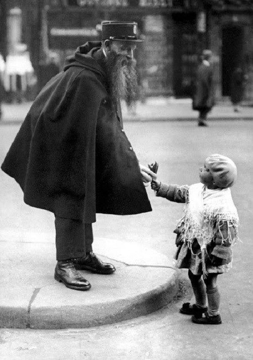 Một bé gái tặng hoa cho vị cảnh sát đang làm nhiệm vụ ở Porte Saint-Dennis, thủ đô Paris, vào khoảng năm 1920.