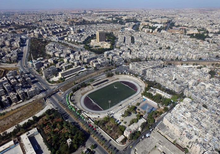 Trong ảnh, những chiếc xe buýt đỗ bên ngoài một sân vận động tại khu vực do chính phủ Syria kiểm soát ở Aleppo để sơ tán những người dân muốn rời khỏi miền đông Aleppo hôm 20/10.