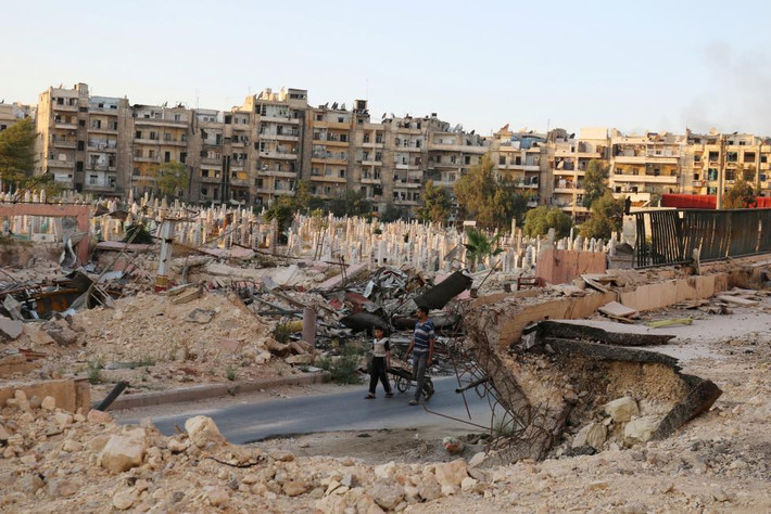 Một khu nghĩa trang quá tải gần đống đổ nát ở al-Shaar, Syria.