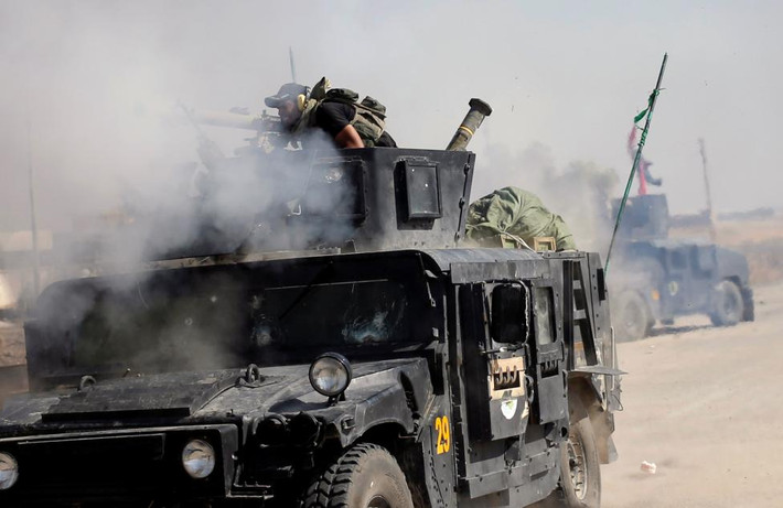 Một binh sĩ đặc nhiệm Iraq nã pháo về phía nhóm IS ở Bartella.