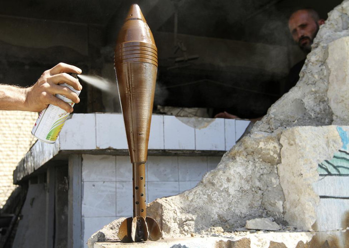 Một chiến binh nổi dậy FSA phun sơn vào quả đạn súng cối ở Aleppo tháng 9/2013.