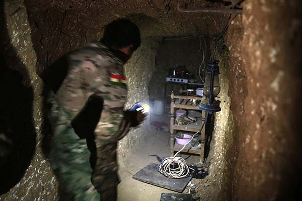 Một chiến binh Peshmerga người Kurd tới khu vực nhà bếp trong hệ thống đường hầm từng được phiến quân IS sử dụng ở thị trấn Badana ngày 18/10/2016.