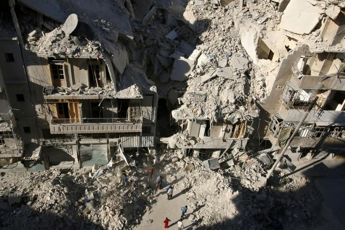 Người dân tìm kiếm những người sống sót trong đống đổ nát ở Tariq al-Bab, Aleppo.