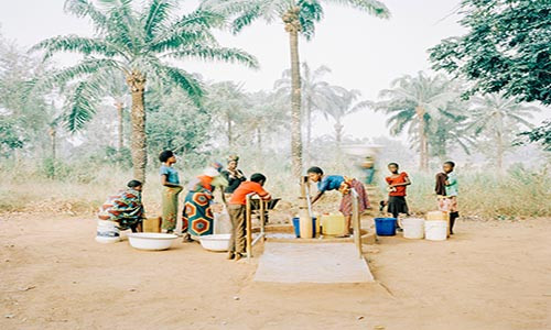 Mọi người tập trung lấy nước tại một giếng nước bơm bằng tay ở Osukputu, Benue, Nigeria, năm 2015.