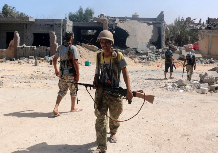 Chiến binh thuộc lực lượng Libya cầm vũ khí trong cuộc giao tranh với các tay súng IS ở thành phố Sirte ngày 3/10.