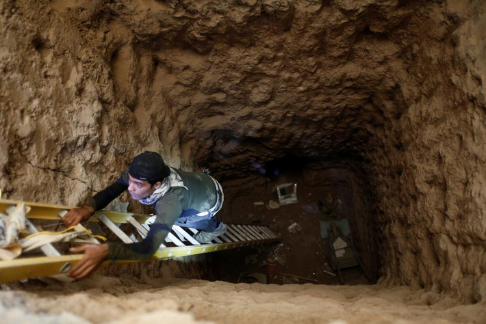 Binh sĩ Iraq sử dụng thang để trèo xuống một đường hầm bên trong một ngôi nhà ở Bartalla, ngoại ô Mosul, hôm 27/10.