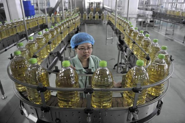 Công nhân đứng dây chuyền sản xuất dầu ăn ở một nhà máy tại Hà Bắc.