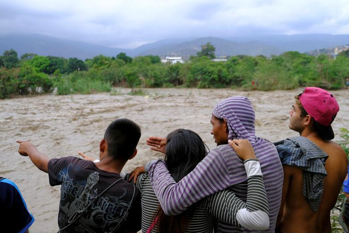 Mọi người đứng trên bờ sông Tachira ở khu vực biên giới giữa Colombia và Venezuela.