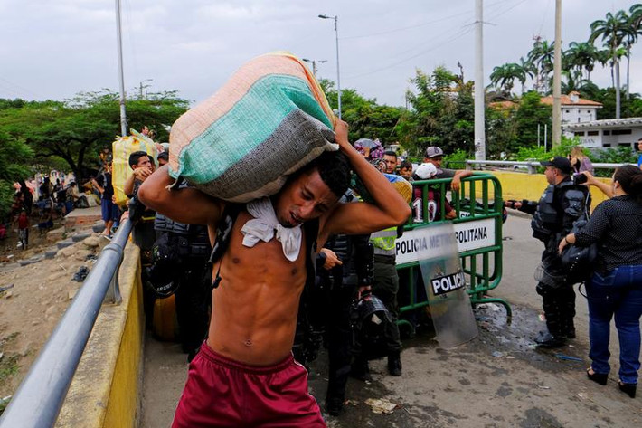 Người đàn ông khiêng bao hàng qua cây cầu quốc tế Simon Bolivar phía Cucuta, Colombia, ngày 2/4.