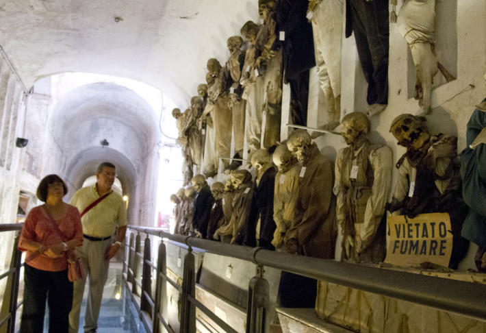 Hai du khách đi qua những xác ướp được bảo quản trong hầm mộ Capuchin ở Palermo, Sicily, miền nam Italy.