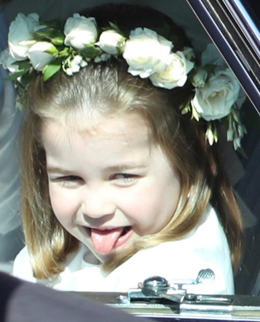 Tiểu Công chúa Charlotte lè lưỡi khi ngồi trên ô tô tới dự đám cưới của chú, Hoàng tử Harry, và cô dâu Meghan Markle tại nhà nguyện St.George ở Lâu đài Windsor ngày 19/5/2018.