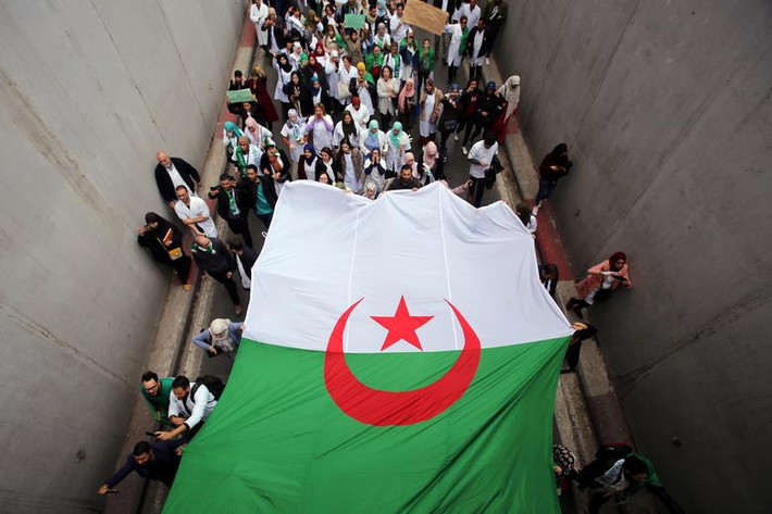 Các nhân viên y tế mang theo quốc kỳ tham gia cuộc tuần hành kêu gọi Tổng thống Algeria Abdelaziz Bouteflika từ chức ở thủ đô Algiers ngày 19/3.