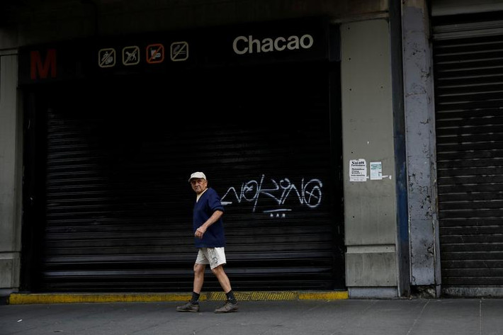Người đàn ông đi qua nhà ga tàu điện ngầm đóng cửa ở Caracas ngày 26/3.