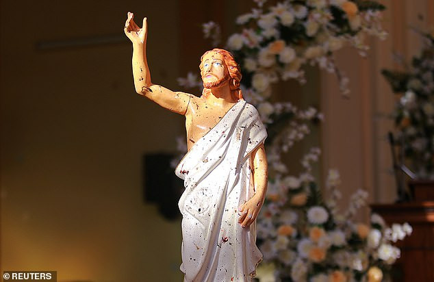 Một bức tượng Chúa trong nhà thờ St.Sebastian bị dính máu sau vụ đánh bom. Ảnh: Reuters.