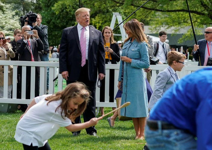 Ông Trump trò chuyện với phu nhân Melania trong lúc các em nhỏ hào hứng lăn trứng ngày 22/4.