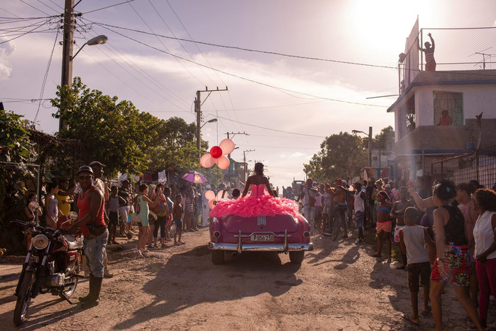 Vấn đề đương đại/Ảnh đơn: Một thiếu nữ đi vòng quanh nơi cô sống tại Havana, thủ đô Cuba, trên một chiếc xe màu hồng từ những năm 1950, giữa sự cổ vũ của những người khác, nhân dịp sinh nhật 15 tuổi. Ảnh: Diana Markosian/Magnum Photos.