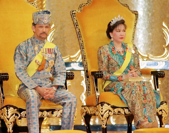 Quốc vương Hassanal Bolkiah đã 3 lần kết hôn và mỗi đám cưới của ông tiêu tốn hàng triệu bảng Anh. Ảnh: Quốc vương Hassanal Bolkia và người vợ thứ hai, Hajah Mariam, ngồi trên ngai vàng trong buổi lễ mừng sinh nhật thứ 50 của ông Bolkia.