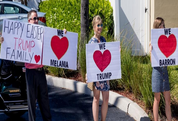 Những người ủng hộ đứng bên đường khi đoàn xe chở Tổng thống Trump trên đường tới sân bay quốc tế Palm Beach ngày 21/4.
