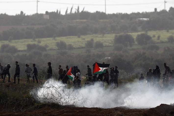 Những người biểu tình Palestine mang theo cờ tuần hành dọc hàng rào biên giới Gaza-Israel ngày 30/3.