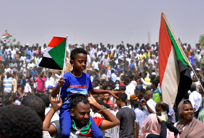 Người biểu tình Sudan mang quốc kỳ và hô vang khẩu hiệu bên ngoài trụ sở Bộ Quốc phòng ở Khartoum ngày 11/4.