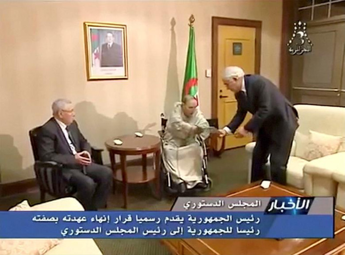 Tổng thống Abdelaziz Bouteflika trao thư từ chức cho Chủ tịch Hội đồng Hiến pháp Tayeb Belaiz trong khi Chủ tịch Thượng viện Abdelkader Bensalah (trái) ngồi bên cạnh ngày 2/4. Ảnh: Reuters.