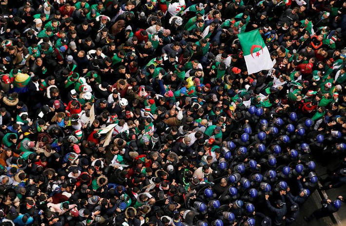 Cảnh sát Algeria cố gắng giải tán đám đông người biểu tình ở thủ đô Algiers ngày 22/3. Ảnh: Reuters.