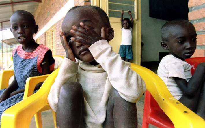Các em nhỏ ngồi trong một trại trẻ mồ côi gần thủ đô Kigali ngày 11/7/1994. Được biết, người thân của các em nhỏ này đã bị lực lượng dân quân Hutu sát hại trong nạn diệt chủng tại Rwanda 25 năm trước.