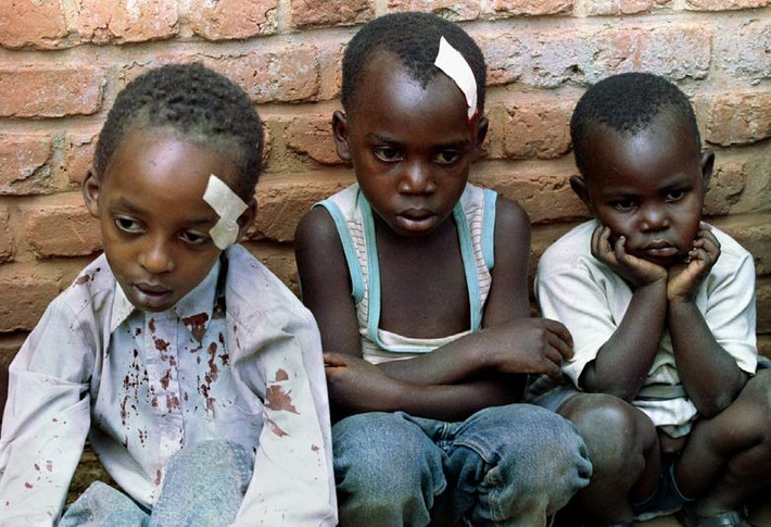 Những đứa trẻ mồ côi Rwanda ngồi bên ngoài một ngôi nhà sau khi trại trẻ mồ côi của chúng bị nã pháo ngày 28/5/1994.