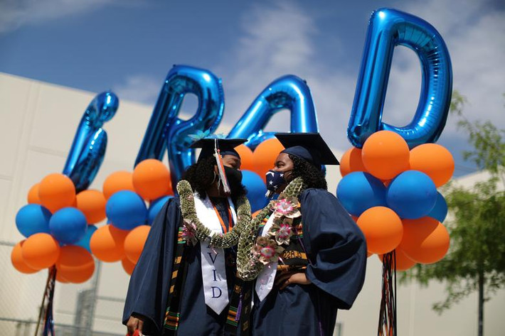 Laila Lacy, 17 tuổi, và Ashley Williams, 17 tuổi, đeo khẩu trang trong buổi lễ tốt nghiệp trung học tại Los Angeles, California, ngày 12/6.