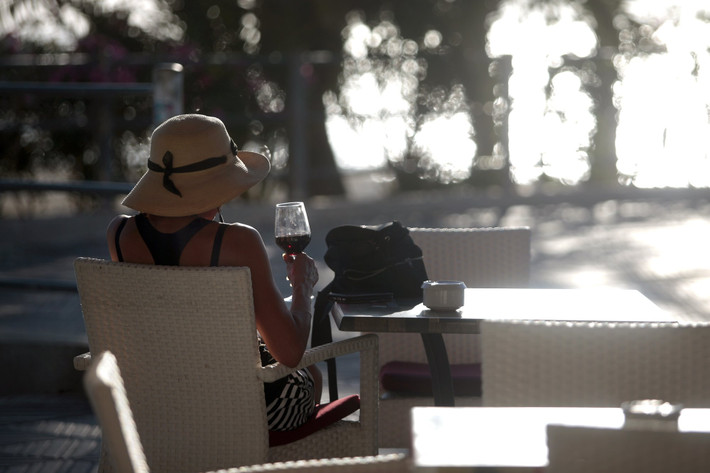 Người phụ nữ ngồi trong quán bar gần bãi biển Palma de Mallorca ở Tây Ban Nha ngày 15/6.