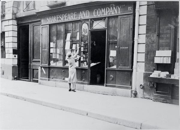 Sylvia Beach, chủ sở hữu của cửa hàng sách Shakespeare & Company ở Paris trang trí cửa của hiệu sách.